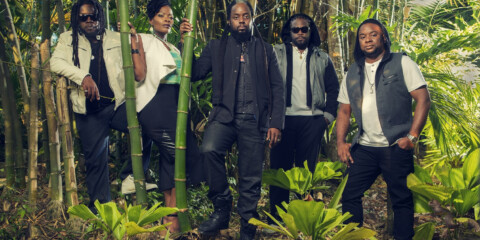 Morgan Heritage Group standing in front of bushes